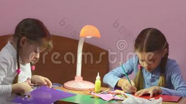 两个孩子做手工，一个用剪刀剪彩色纸板，第二个标记剪点铅笔